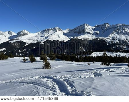 Beautiful Sunlit And Snow-capped Alpine Peaks Above The Swiss Tourist Sports-recreational Winter Res