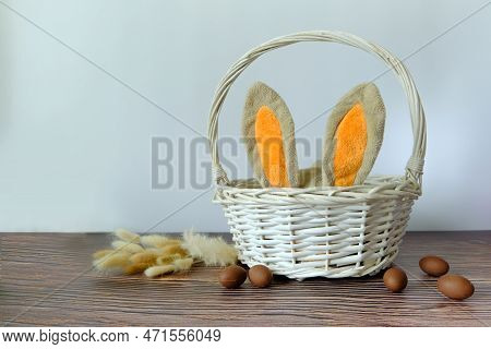 Easter Eggs And A White Basket With Rabbit Ears