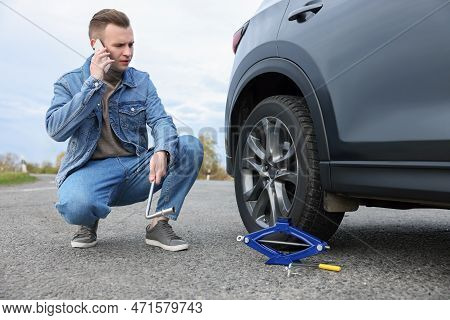 Worried Young Man Calling Car Service. Tire Puncture