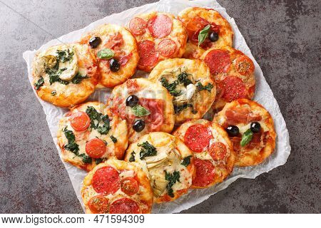 Pizzette Italian Mini Pizzas Or Pizza Bites Close-up On Parchment On The Table. Horizontal Top View 