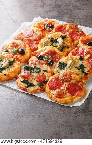 Mix Mini Pizza Or Pizzette With Various Toppings Close-up On Parchment On The Table. Vertical