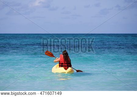 Kayaking In The Sea, Girl Wearing Life Vest Sitting With Paddle In Canoe. Travel And Water Sports Co