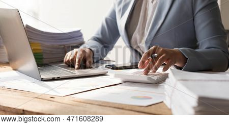 Business Woman Using Calculator To Calculate Financial Report, Working At Office With Laptop Compute
