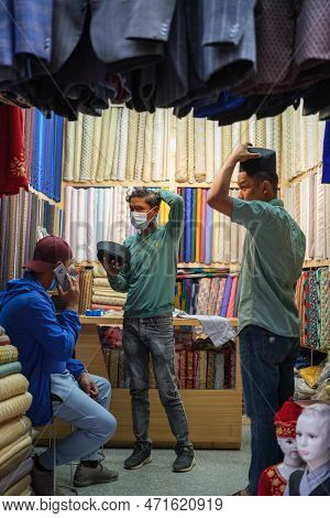 Kathmandu, Nepal, 04 23 2022: Trying On Hats In Kathmandu Bazaar
