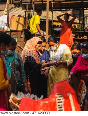 Kathmandu, Nepal, 04 23 2022: Three Women Looking For The Way On Kathmandu Bazaar In A Map