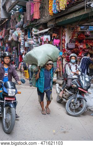 Kathmandu, Nepal, 04 23 2022: Man Carrying A Sack Of Wares