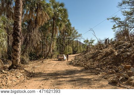 Car On A Dusty Gravel Road Along The Kunene River In Northern Namibia