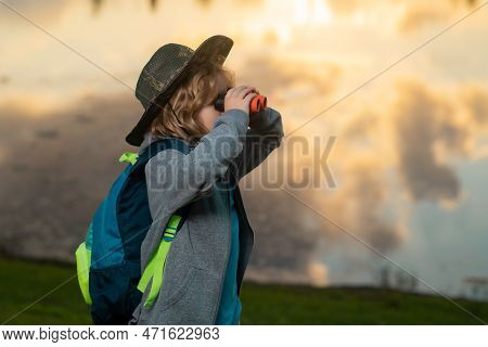 Young Boy Looking Through Binoculars. Imagination Or Exploration In Park. Happy Child Playing With B