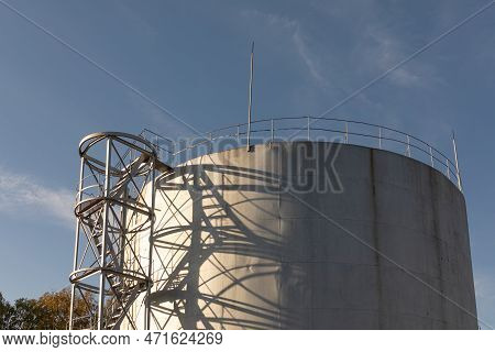 A Large Oil Storage Tank Against A Blue Sky. Storage, Processing, Chemical Industry Equipment. Tank 