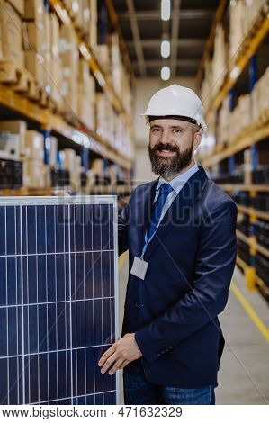 Portrait Of Manager Holding A Solar Panel In A Warehouse.