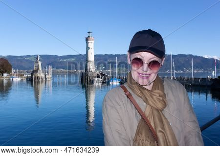 Portrait Of A Mature Woman In A Baseballcap And A Scarf Around Her Neck On The Embankment In Lindau