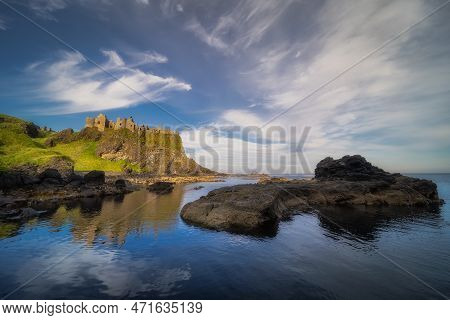 Dunluce Castle Reflected In Ocean, Nested On The Edge Of Cliff, Part Of Wild Atlantic Way, Northern 