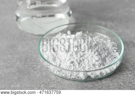 Petri Dish With Calcium Carbonate Powder On Light Grey Table, Closeup