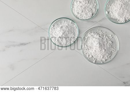 Many Petri Dishes With Calcium Carbonate Powder On White Marble Table, Flat Lay. Space For Text