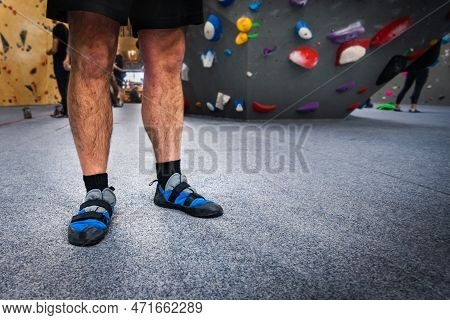 Male Climber Wearing Indoor Climbing Wall Shoes On His Feet, Standing On Soft Flooring Safety Mat. C