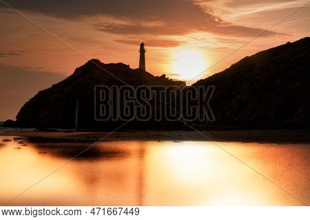 Castlepoint Lighthouse At Sunrise Creating A Silhouette Of The Rock And Lighthouse