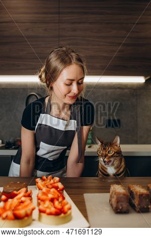 A Cat In An Apron And A Cap Rolls Out The Dough. Cooking At Home.