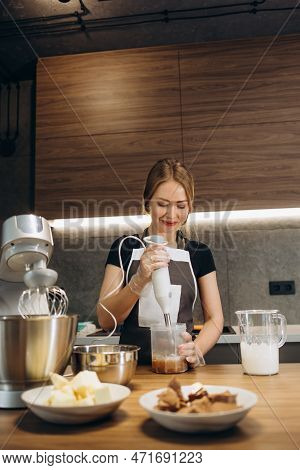 Beautiful Young Chef Decorating Delicious Dessert  In Modern Kittchen