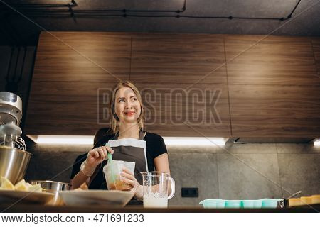 Beautiful Young Chef Decorating Delicious Dessert  In Modern Kittchen