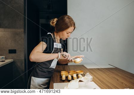 Beautiful Young Chef Decorating Delicious Dessert  In Modern Kittchen