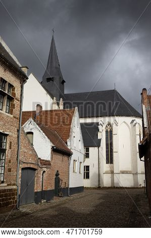 View Of Diest Beguinage And St. Catherines Church, In Flemish Brabant In Belgium, Against A Dramatic
