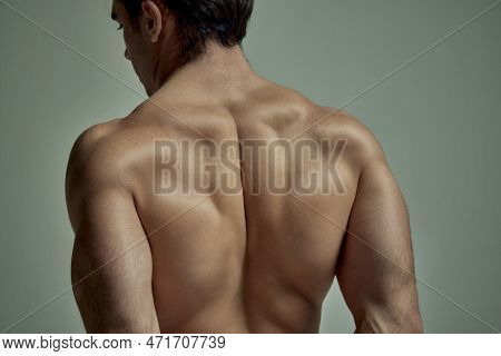 Cropped Image Of Strong Muscular Male Body, Shoulders, Relief Back Over Pale Green Studio Background