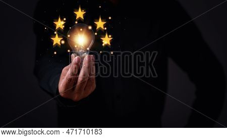 Businessman Holding A Light Bulb Concept Of Global Business To Driven Startup With Five Stars Succes