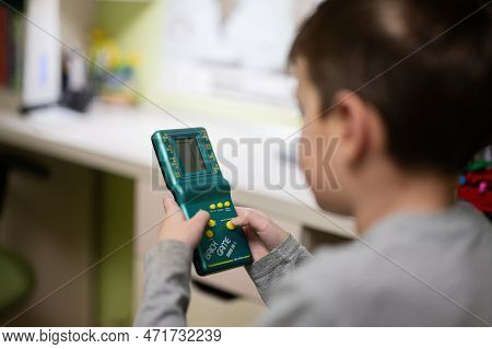 Ternopil, Ukraine - February, 2023: Boy Is Playing With An Green Electronic Tetris.