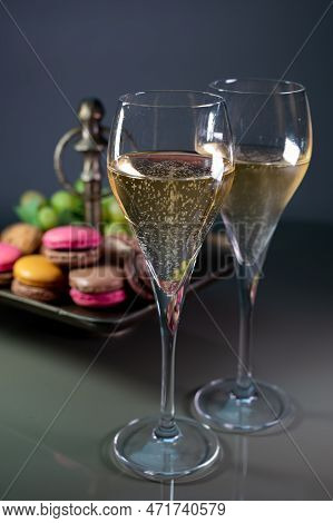 Glasses Of Sparkling White Wine Champagne Or Cava With Bubbles And Sweet Dessert Colorful Macarons B