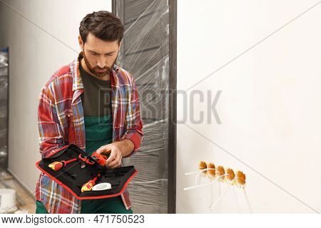 Electrician Taking Pilers From Tool Bag Indoors
