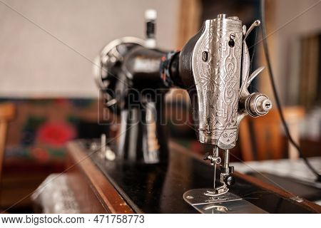 An Old Sewing Machine Stands On The Table At Home Ready To Work And Sew. Classic Retro Style Manual 