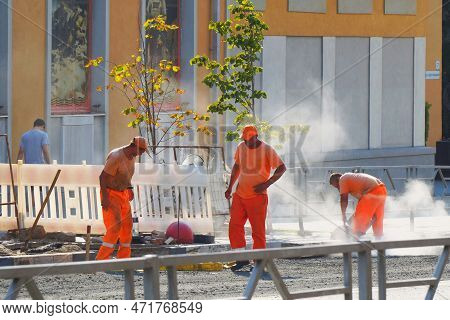 Samara, Russia - Circa March, 2022: Uniformed Road Workers Work On A City Street Laying A Curb