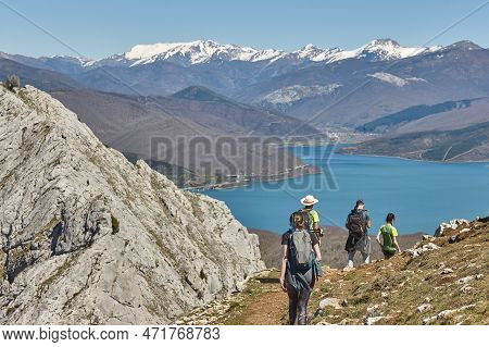Picturesque Reservoir And Mountain Landscape In Riano. Hikers. Spain