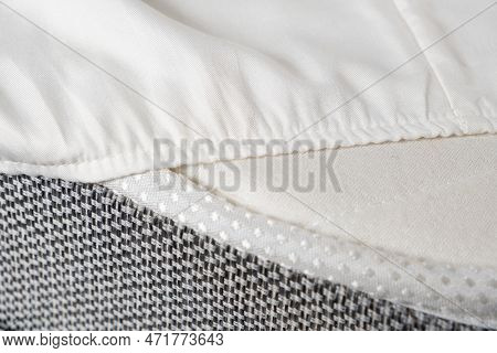 White Satin Sheet On An Elastic Band On The Mattress. Bed Linen On The Bed