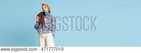 Beautiful Happy Young Girl, Student In Headphones And Casual Clothes Posing With Tablet Over Blue St