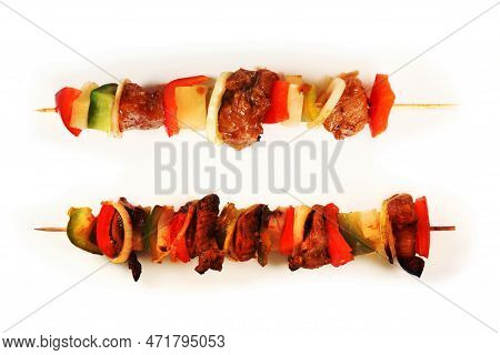 A Picture Of Two Shashlicks One Grilled And One Raw Over White Background