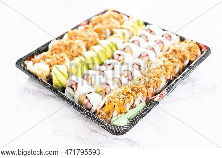 Pre-packaged Variety Of Sushi And Sushi Rolls In A Plastic Tray.
