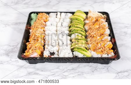 Pre-packaged Variety Of Sushi And Sushi Rolls In A Plastic Tray.