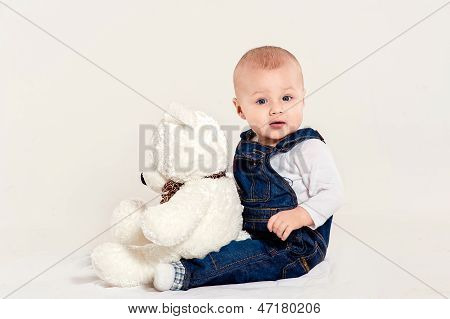the little boy plays with a teddy bear