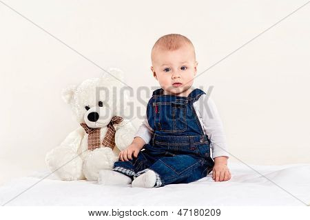 the little boy plays with a teddy bear