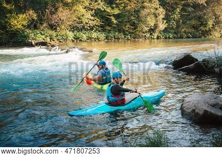 Two Whitewater Kayakers Paddling On The Waters Of River. Adrenaline Seekers And Nature Lovers.