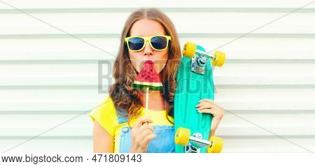 Portrait Young Woman With Skateboard Eating Ice Cream Shaped Watermelon Over White Background
