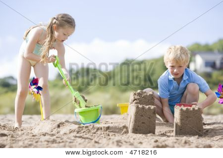 Bruder und Schwester am Strand machen Sand castles