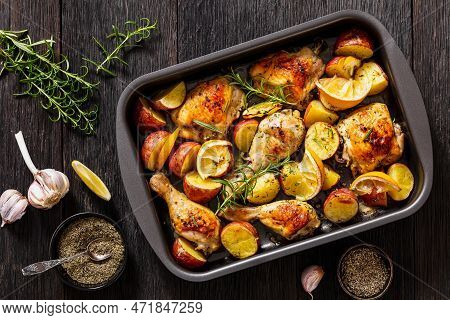Lemon Garlic Chicken With Roasted Potatoes, Spices And Herbs On Sheet-pan On Dark Wood Table With Ng