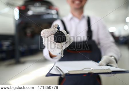 Car Repair And Maintenance Services. Master Holds Key And Documents For Car In Auto Repair Shop Conc