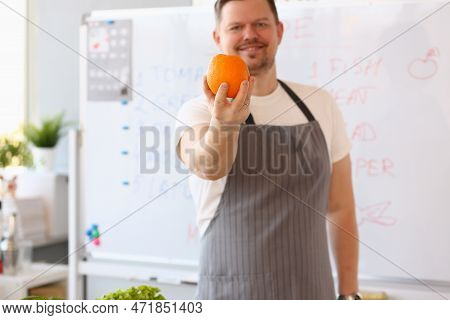 Male Blogger Cook Holding Orange And Giving Training Lesson On How To Cook Healthy Food. Remote Trai