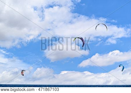 People Practicing Kitesurfing On The Beach Of Los Caños De Meca, Next To The Trafalgar Lighthouse, B