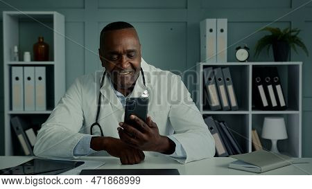 African Doctor Man Middle-aged Worker Use Cellphone Gadget Texting Message Chatting Consulting Clien