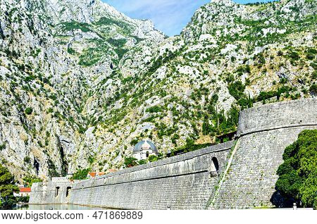 View Of The Kampana Tower, Wall Of The Ancient Fortress Of Kotor, Under The Mountains. Montenegro.