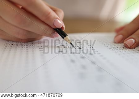 Close-up Of Woman Solving Tests And Writing With Pencil On Paper. Exam Testing Concept
